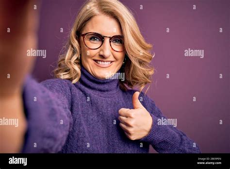 Middle Age Beautiful Blonde Woman Wearing Sweater And Glasses Make Selfie By The Camera Happy
