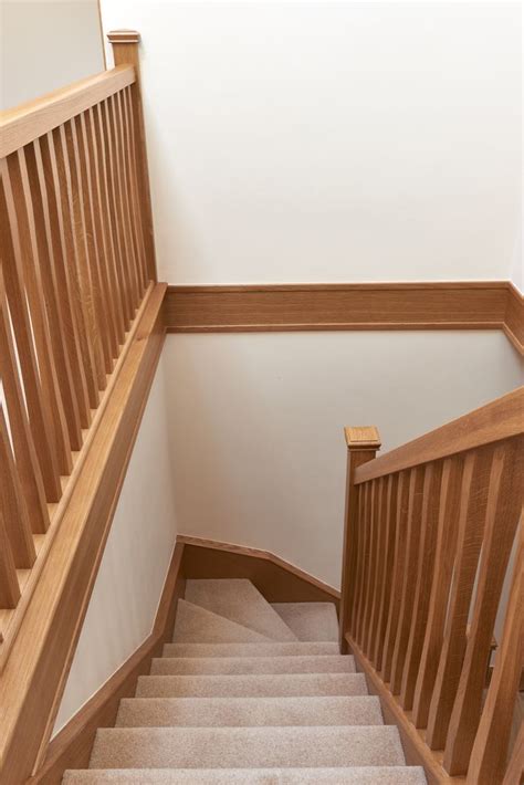 The Stairs Are Made Of Wood And Have White Carpet