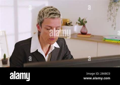 Professional Mature Businesswoman Working At Desk Working On Desktop