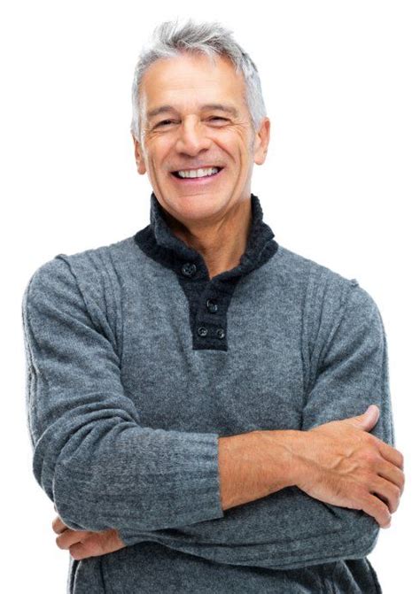 An Older Man With His Arms Crossed And Smiling At The Camera While Wearing A Gray Sweater