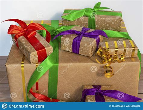 Gifts Packed In Craft Paper And Tied With Satin Ribbon On A Wooden