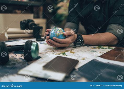 Globe Whole World In Hands And Compass Magnifying Glass And Book On Route Map On The Table