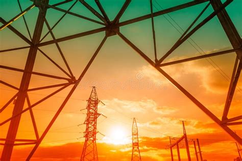 High Voltage Post And Power Lines At Sunset Electricity Pylons In A Row