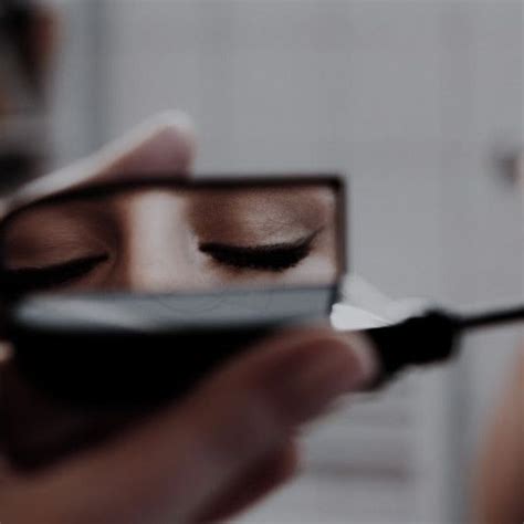 A Woman Holding A Cell Phone With Her Eyes Closed And Eyelashes