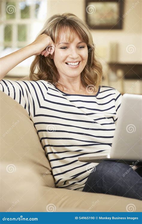 Mature Woman Sitting On Sofa At Home Using Laptop Stock Photo Image Of Woman Aged