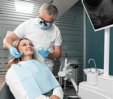 The Dentist Examines The Patient S Oral Cavity Before Starting Dental