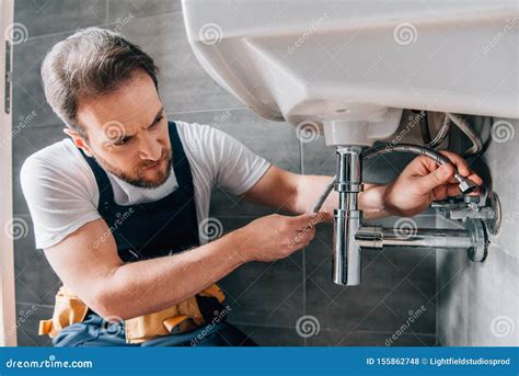 Serious Male Plumber In Working Overall Fixing Sink Stock Photo Image