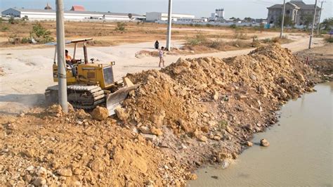 First Starting New Project Showing Bulldozer Push Stone In Water With