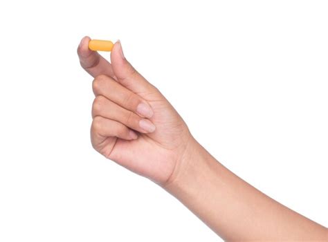 Premium Photo Hand Holding A Pill Between Thumb And Forefinger