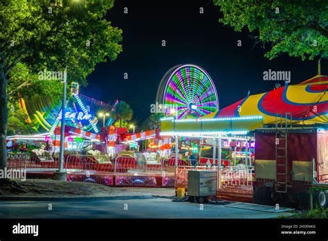 Wide View Of Several Rides At A Traveling Amusement Park And Concession