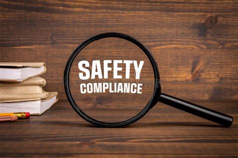 Safety Compliance Concept Magnifying Glass On A Dark Wooden Background