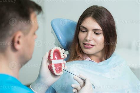 Doctor Orthodontist Explains To The Patient How The Braces Are Arranged