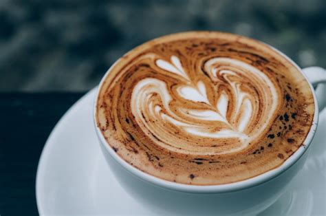Premium Photo Cup Of Hot Latte Art Coffee On Wooden Table