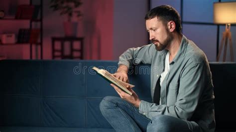 Pensive Bearded Man Reading Book At Home Late Evening Lighting Dusk