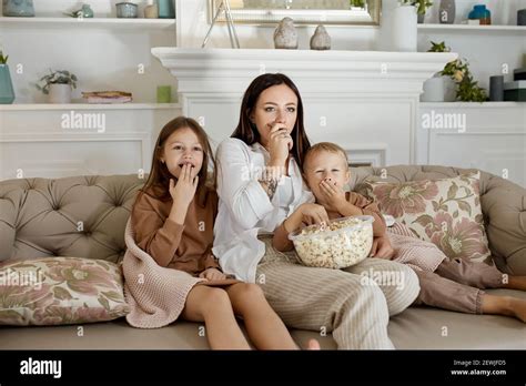 Maman S Assoit Sur Le Canap Avec Son Fils Et Sa Fille Et Regarde Un