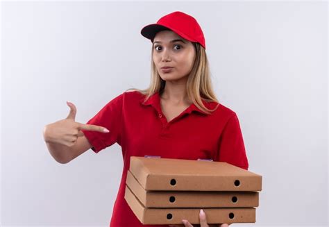 Repartidor Joven Vistiendo Uniforme Rojo Y Gorra Sosteniendo Y Apunta A