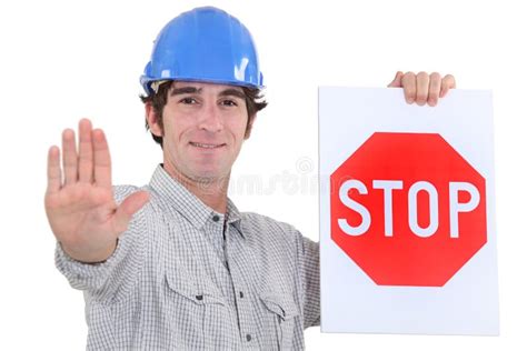 Construction Worker Holding Stop Sign On City Street Stock