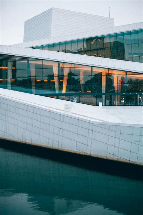 Modern Opera House Exterior Against River In Town · Free Stock Photo