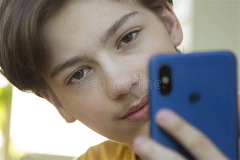 Adolescente Segurado Em Smartphone Manual Garoto Olha No Celular E