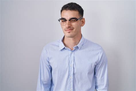 Handsome Hispanic Man Wearing Business Clothes And Glasses Winking