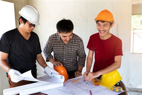 Engineer And Architect Discussing With Foreman About Project In