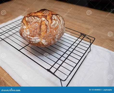 Freshly Baked Loaf Of Bread Rests On Wire Cooling Rack Stock Photo