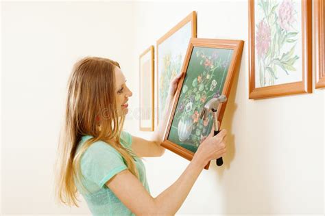 Smiling Blonde Woman Hanging Picture Stock Photo Image Of Paintings Frame 34766742