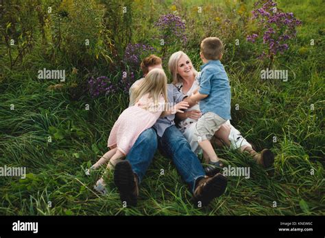 Parents And Children Lying In Tall Grass Together Stock Photo Alamy