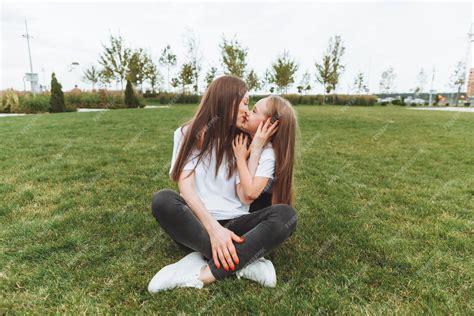 Une Mère Heureuse Et Sa Fille Sont Assises Sur Lherbe Dans Le Parc Et étreignent La Famille