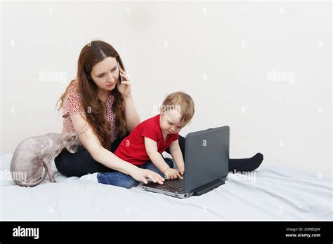 Young Mother Working From Home Talking On Smartphone While Spending