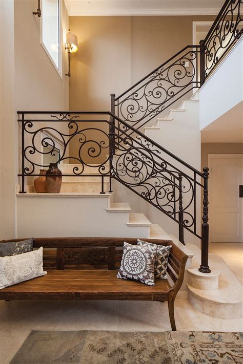 A Wooden Bench Sitting Under A Stair Case Next To A Bannister And Table