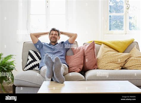 Man Sitting On Couch At Home Relaxing Stock Photo Alamy