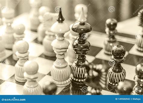 Two Chess Pieces Of Kings On A Wooden Board Surrounded By Other Chess