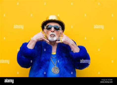 Funny And Extravagant Senior Man Posing On Colored Background