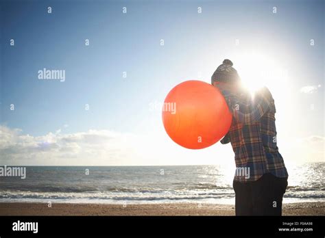 Mature Man Blowing Up Inflatable Hopper At Beach Stock Photo Alamy
