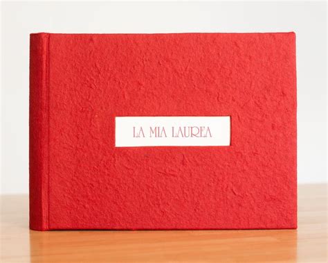 A Red Book With The Word La Mia Lauria On It Sitting On A Wooden Table