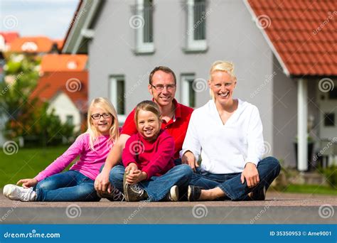 Famille Heureuse S Asseyant Devant La Maison Image Stock Image Du