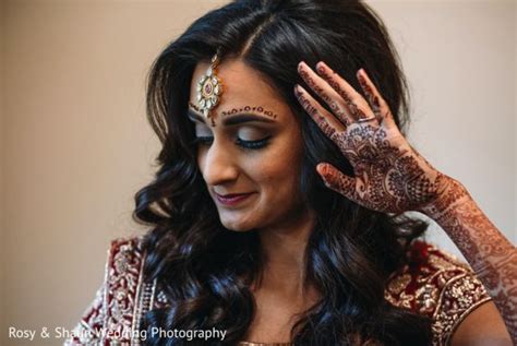 A Woman With Henna On Her Face And Hands Holding The Top Of Her Head