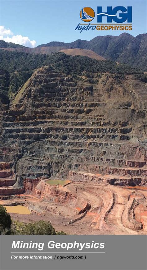 A Stepped Open Pit Mine Set Against A Backdrop Of Mountains Under A