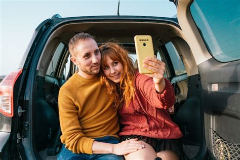 Joven Pareja Feliz Tomando Un Selfie Sentado En El Maletero Del Coche