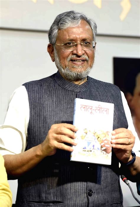 BJP MP Sushil Kumar Modi poses with a Book during a press conference