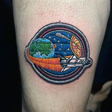 Space shuttle patch tattoo located on the thigh.