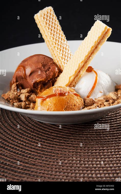 Assorted Ice Creams Scoops Garnished With Nuts And Wafers Stock Photo