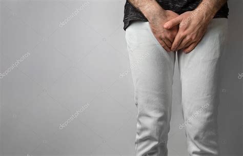 El Hombre De Jeans Blancos Dobl Sus Manos Al Nivel De Sus Genitales