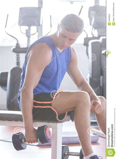 Homem Novo Que Exercita Usando O Peso Foto De Stock Imagem De