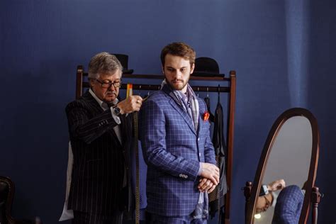 Mature Professional Tailor Taking Measure Leg Measuring Of Client