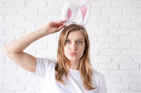 Premium Photo Portrait Of A Happy Woman In Bunny Ears On White Brick