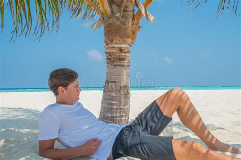 Handsome Man Relaxing On The Beach At The Tropical Island Luxury Resort