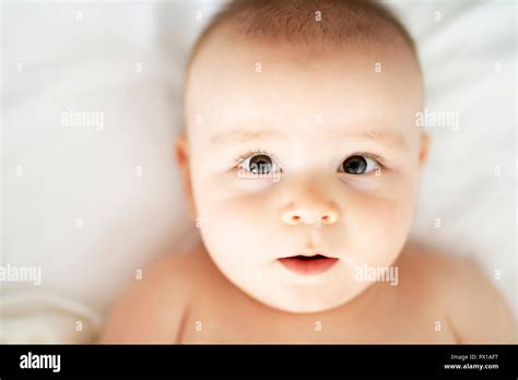 Happy Cute Baby Lying On White Sheet Stock Photo Alamy