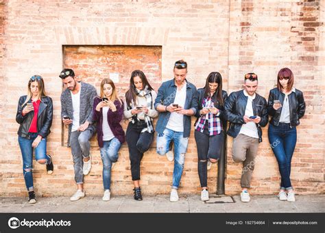 Friends Group Using Smartphone Against Wall At University College